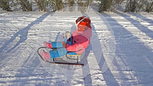 Girl rides a sled through the snow