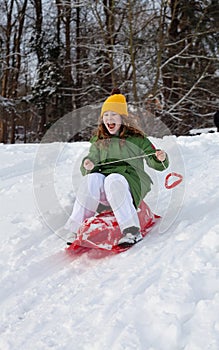 Girl rides sledge down hill