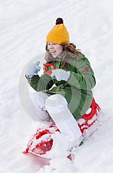 Girl rides sledge down hill