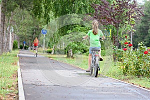 Girl rides on a special bike path in a city park