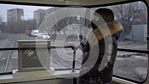 Girl rides a tram wearing a mask. Slow motion