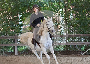 A girl riding an arabian white horse