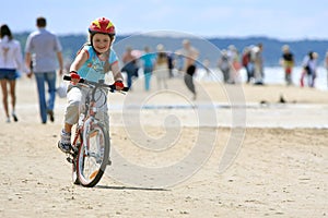 Girl riding with bicycle along the beach