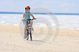 Girl riding with bicycle along the beach
