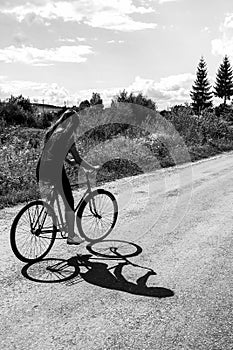 Girl riding a bicycle on a road on a sunny summer day, vacation