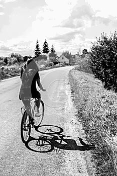 Girl riding a bicycle on a road on a sunny summer day, vacation