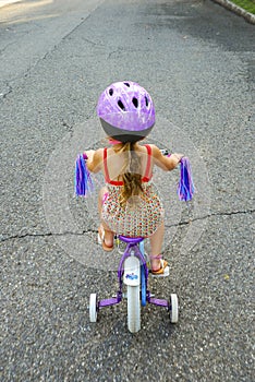 Girl Riding Bicycle with Training Wheels