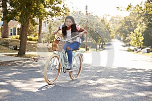 Girl Riding Bike Along Street To School