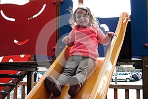the girl is riding on a children& x27;s slide