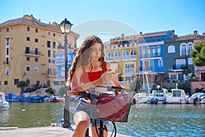 Girl riding a foldable e-bike in a Mediterranean marina