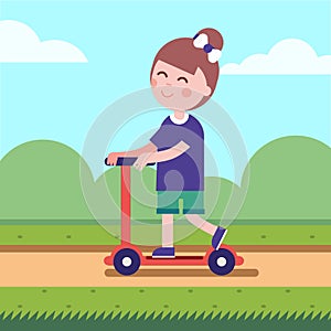 Girl riding her kick scooter on a park road