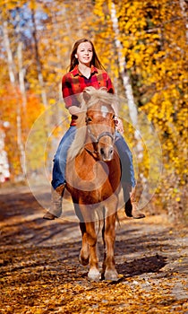 Girl riding horse in the fall time