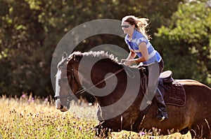 Girl riding horse in meadow photo