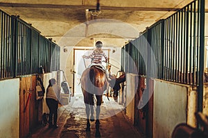 girl riding a horse in a stable.