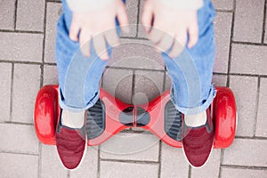 Girl riding on modern red electric mini segway or hover board scooter