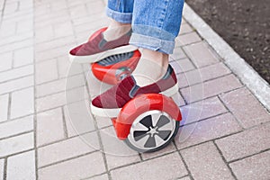 Girl riding on modern red electric mini segway or hover board scooter