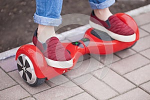 Girl riding on modern red electric mini segway or hover board scooter