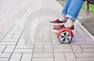 Girl riding on modern red electric mini segway or hover board scooter