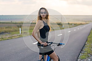 A girl riding a mountain bike on an asphalt road, beautiful portrait of a cyclist
