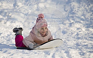 girl riding on snow slides in winter time