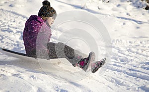 Girl riding on snow slides in winter time