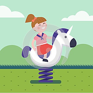 Girl riding a spring horse ride at park playground