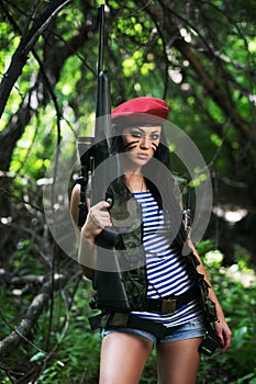 Girl with a rifle in the woods photo