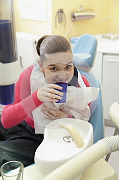 Girl rinsing mouth after dental inspection