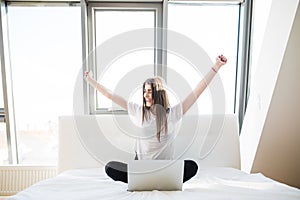 Girl with rised hands in bed photo