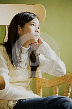 Girl in rocking chair, thoughtful look