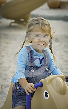 Girl on Rocking Horse in Playground