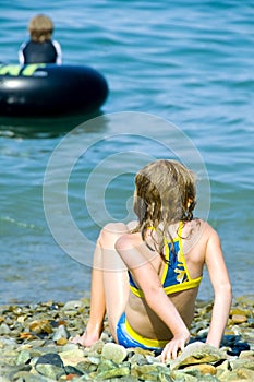 Girl on rocky shoreline