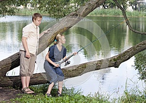 The girl with a rod and the guy looks at it