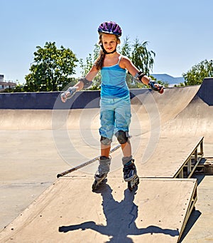 Girl roller in skates park. Child wear safety helmet do sport exercise.