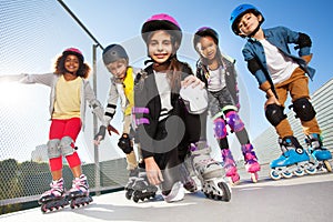 Girl in rollerblades playing with friends outdoors