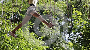 Girl on a rope climbing in park