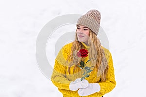 Girl with a rose on the background of snow