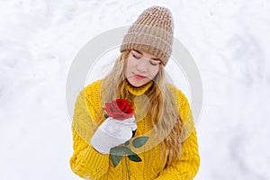 Girl with a rose on the background of snow