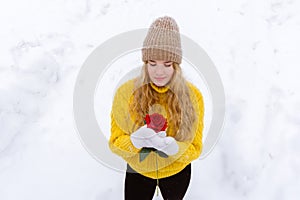 Girl with a rose on the background of snow