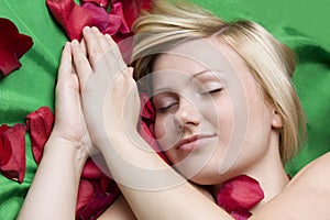 Girl in rose petal on green background