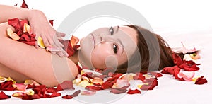 Girl in rose petal. Spa beautician.