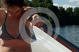 Girl rowing in a boat on the lake. Physical activity. Training. Water sports. At the lake.