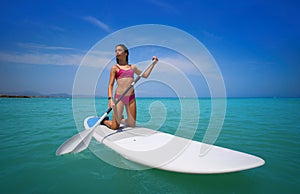 Girl rowing on knees on paddle surf SUP