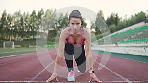 Girl runner takes a position at the start before the race. athlete in sports clothing and smart watches