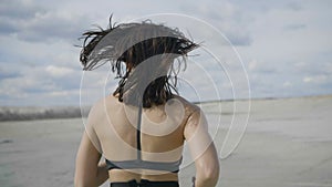 Girl is running along the lake shore