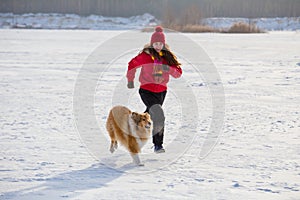 Girl running with collie dog at winter landscape