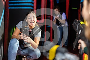 Girl running and dodging while playing lasertag