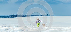 Girl running with dog in snow