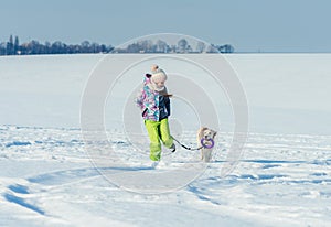 Girl running with dog in snow