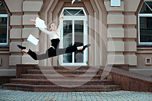 Girl running down the street tossing documents handed.